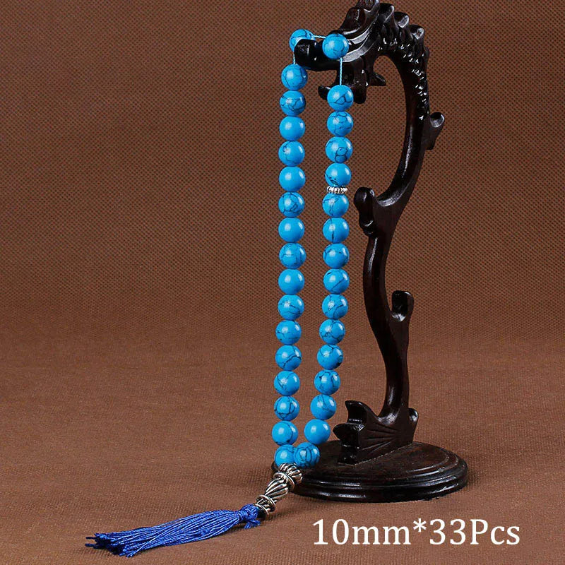 Black agate prayer beads on a stand with a blue tassel necklace