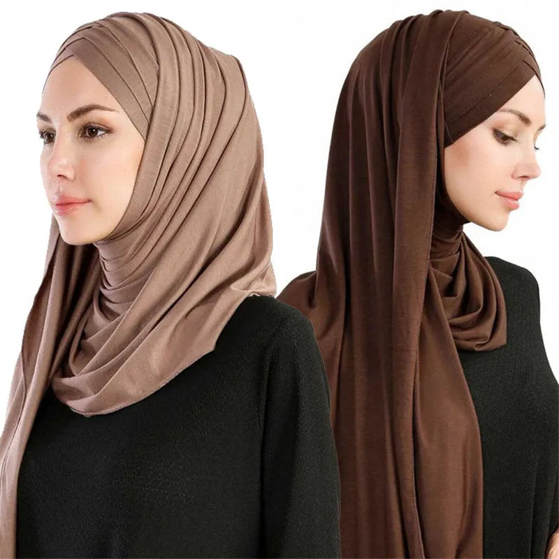 Une femme portant un foulard châle en jersey de coton brun avec un haut noir.