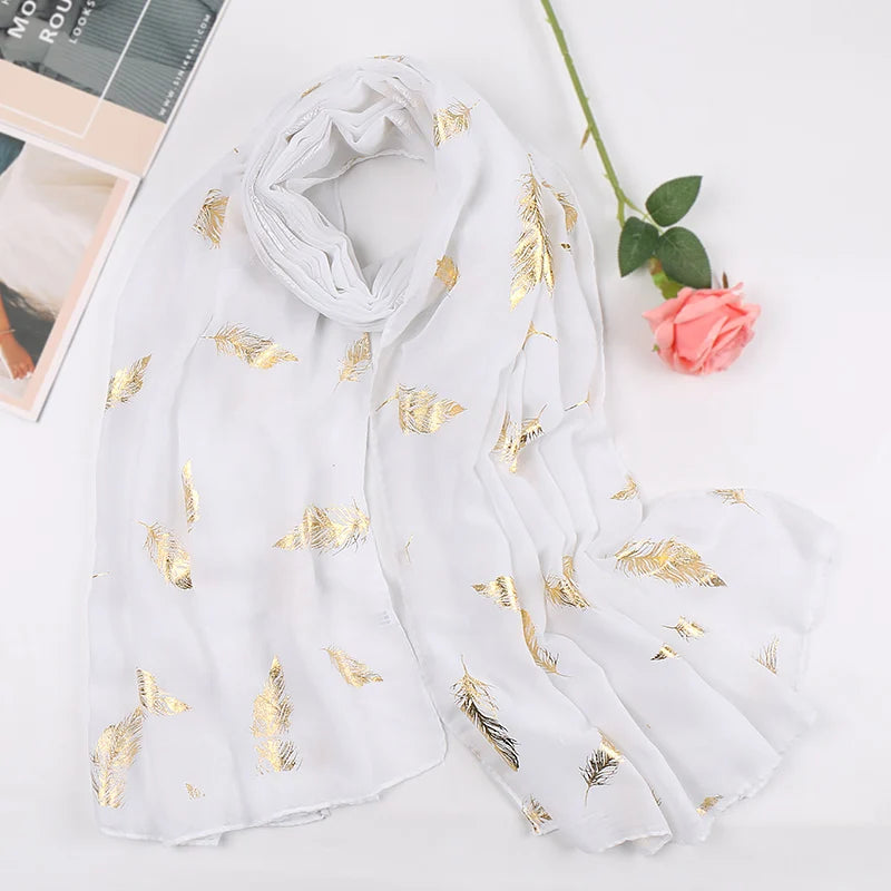 Weißer Chiffon-Hijabschal mit Goldfederdruck, drapiert auf weißem Hintergrund.