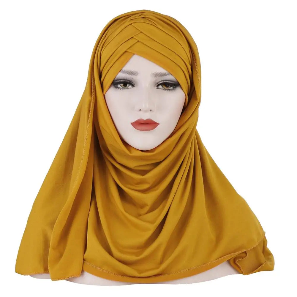 Une femme modélise un châle hijab en jersey de coton jaune moutarde drapé sur sa tête et ses épaules.