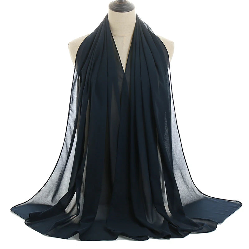 Pañuelo de chifón transparente azul oscuro drapeado sobre un maniquí.
