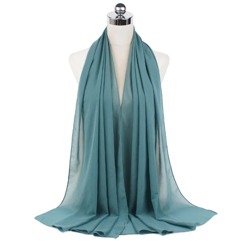 Ein türkisfarbener Chiffon-Instant-Schal über dem Hals einer Mannequin drapiert.