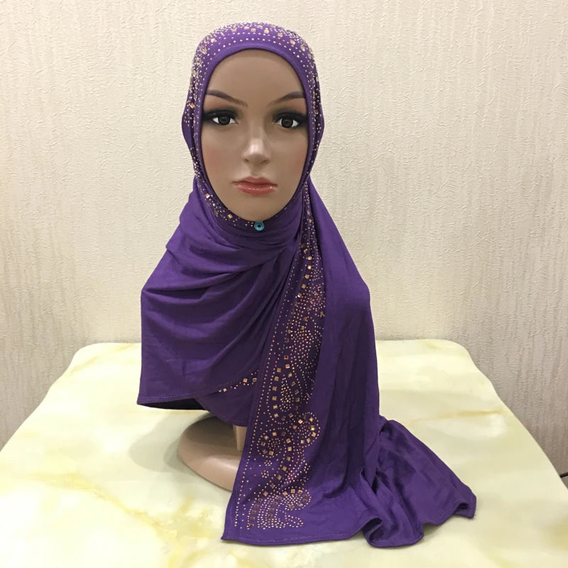 Écharpe de maillot violette avec des ornements de cristal drapée autour de la tête d'un mannequin.