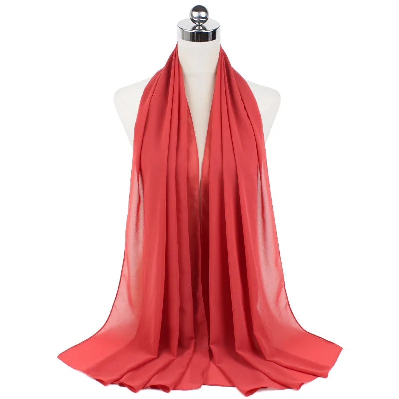 Leuchtend korallenrote Chiffon-Instant-Schal über dem Hals einer Mannequin drapiert.