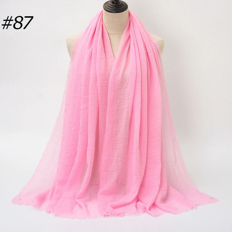 Helles pinkes Crinkle-Baumwoll-Hijab-Tuch um den Hals einer Mannequin drapiert.