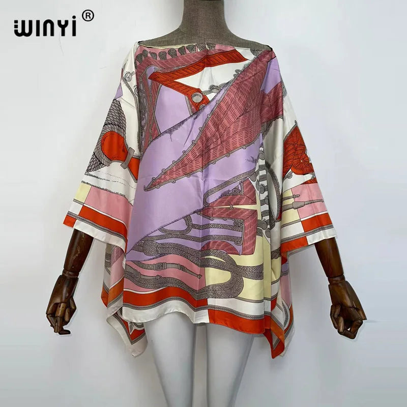 A women's bohemian summer batwing abaya top featuring a colorful, patterned fabric with pink, orange, and purple tones.
