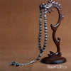 A dark brown wooden prayer beads and tassel necklace displayed on a neutral background.