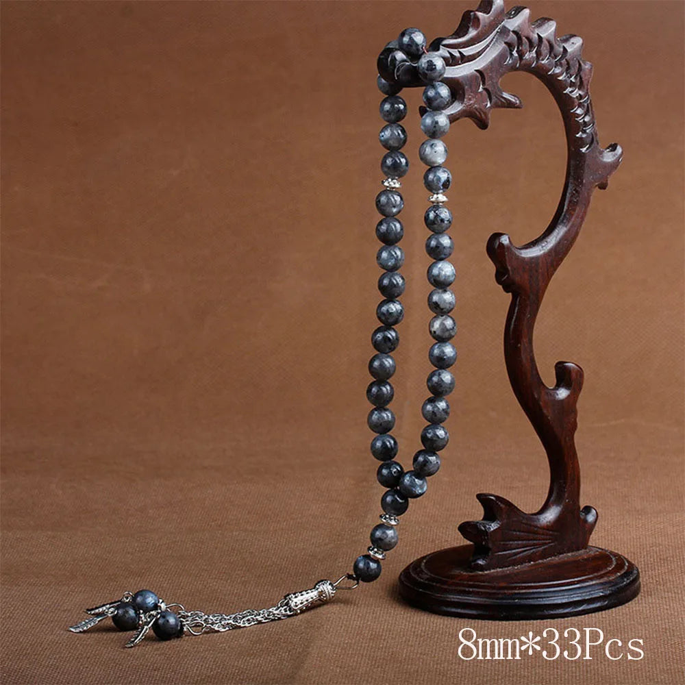 A dark brown wooden prayer beads and tassel necklace displayed on a neutral background.