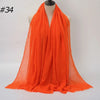 Helles orangefarbenes Crinkle-Baumwoll-Hijab-Tuch über einem Mannequin-Hals drapiert.