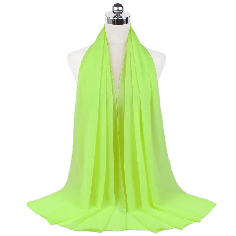 Un pañuelo de chifón verde lima brillante drapeado alrededor del cuello de un maniquí.