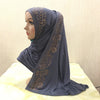Une femme portant un foulard en jersey gris foncé élégant avec des embellissements de cristaux dorés