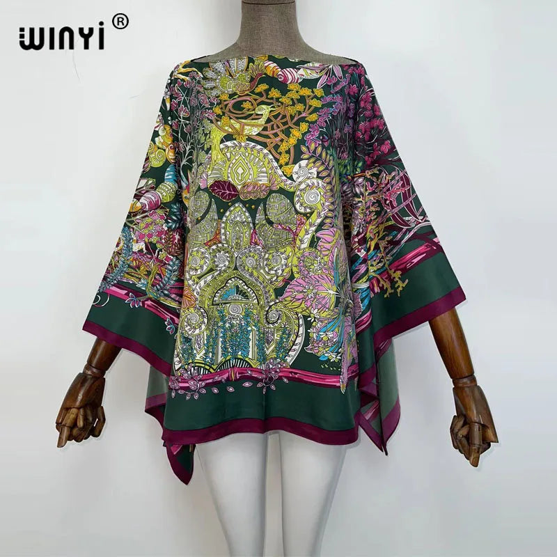 A women's bohemian summer batwing abaya top featuring intricate floral and animal patterns in shades of green, pink, and yell