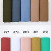Eine Kollektion von crinkligem Baumwoll-Hijab-Schals in verschiedenen Farben wie rosa, grün, braun und blau.