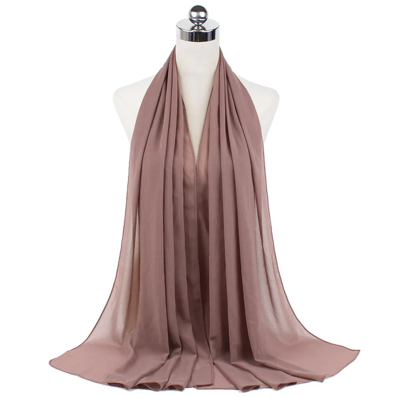 Un pañuelo de chifón malva fluido drapeado alrededor del cuello de un maniquí.