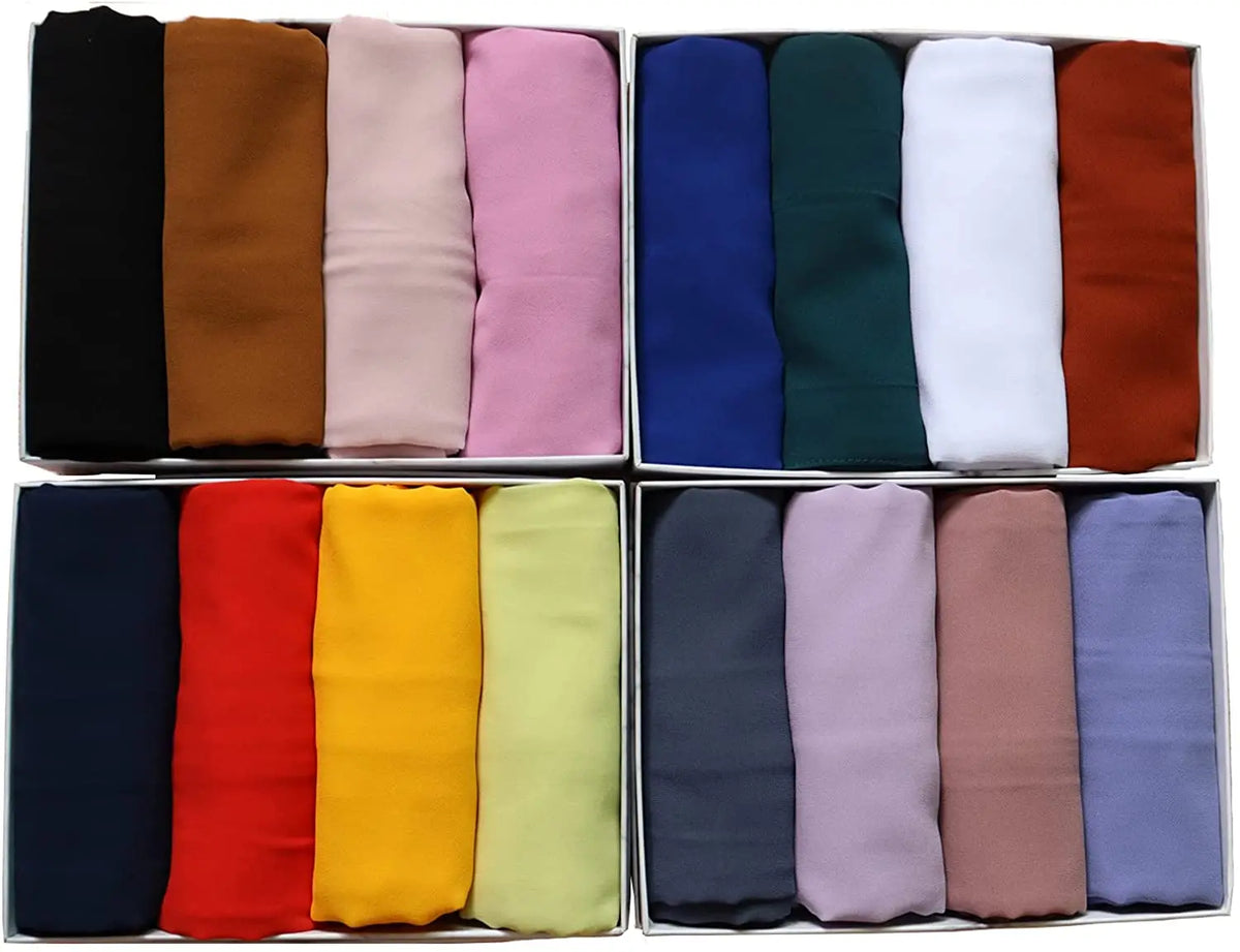Eine Sammlung gefalteter, einfacher Chiffon-Hijabs in verschiedenen einfarbigen Farben wie Schwarz, Braun, Pink, Blau, Grün, 