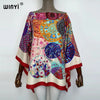 A woman models a colorful bohemian summer batwing abaya top featuring intricate patterns and vibrant colors.