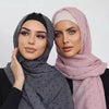 Eine Frau modelliert einen durchgehenden Chiffon-Hijab-Schal in Grau- und Pinktönen.