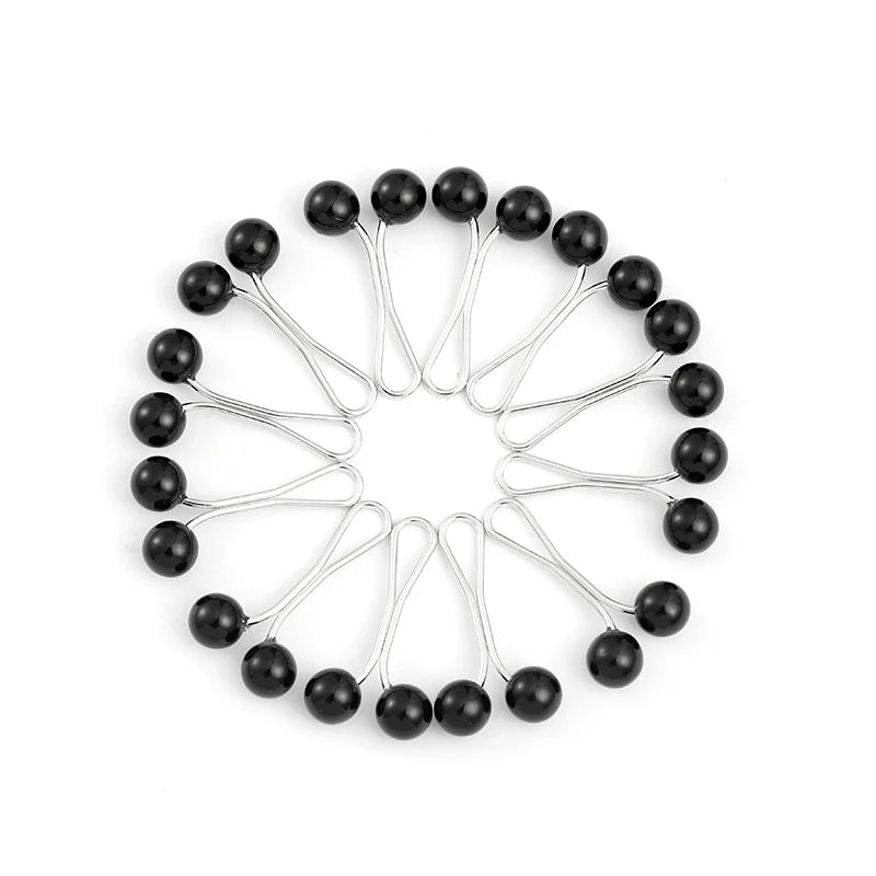 A circular arrangement of twelve silver-toned pins with black pearl-like heads.
