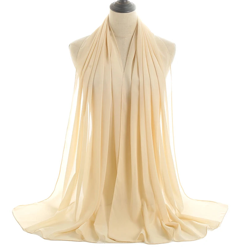 Un pañuelo de chifón color crema drapeado alrededor del cuello y los hombros de un maniquí.