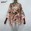A model is wearing a flowing, light pink bohemian summer batwing abaya top with floral and leaf patterns.