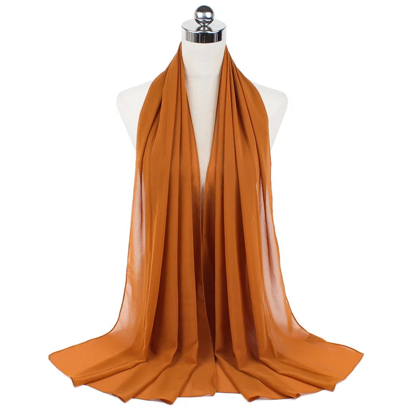 Pañuelo de chifón naranja drapeado exhibido en maniquí.