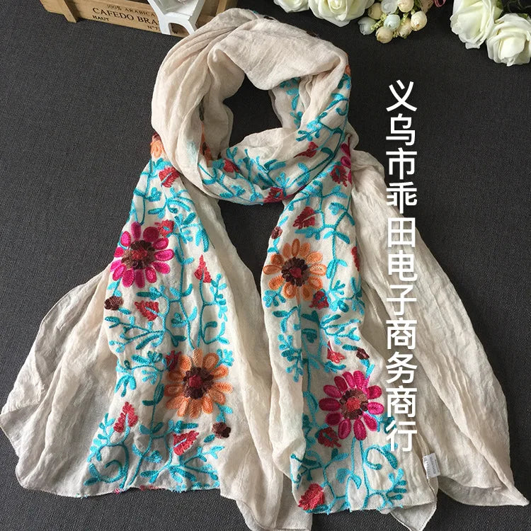 Helles beigees florales besticktes Wintertuch mit rosa, orange und blauen Blumen.