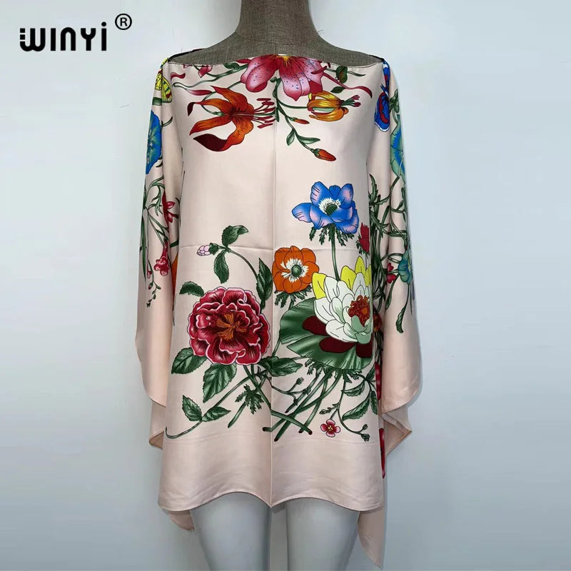 A light pink bohemian summer batwing abaya top featuring a colorful floral print.