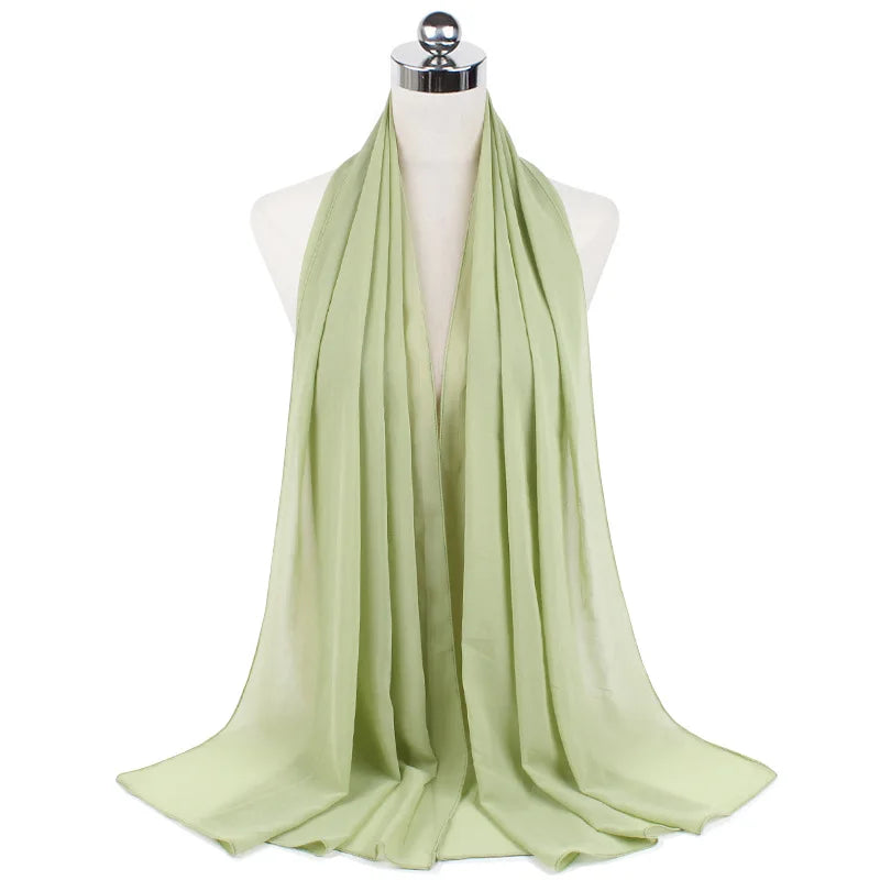 Helles salbei-grünes Chiffon-Instant-Schal über dem Hals eines Mannequins drapiert.