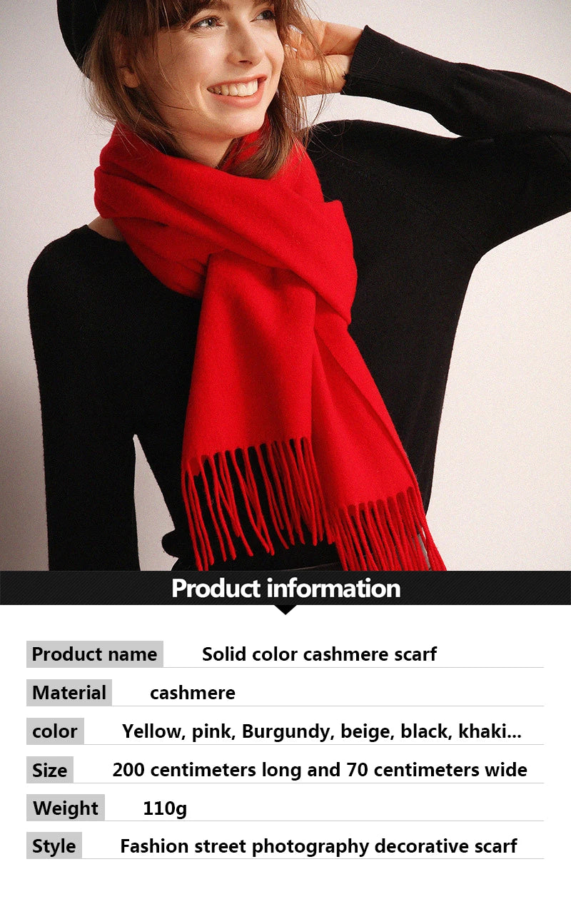 Una mujer modela una bufanda de cachemira roja brillante drapeada alrededor de su cuello y hombros.