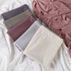 Pila de pañuelos de jersey de algodón de hilo de varios colores en tonos malva, gris y beige.