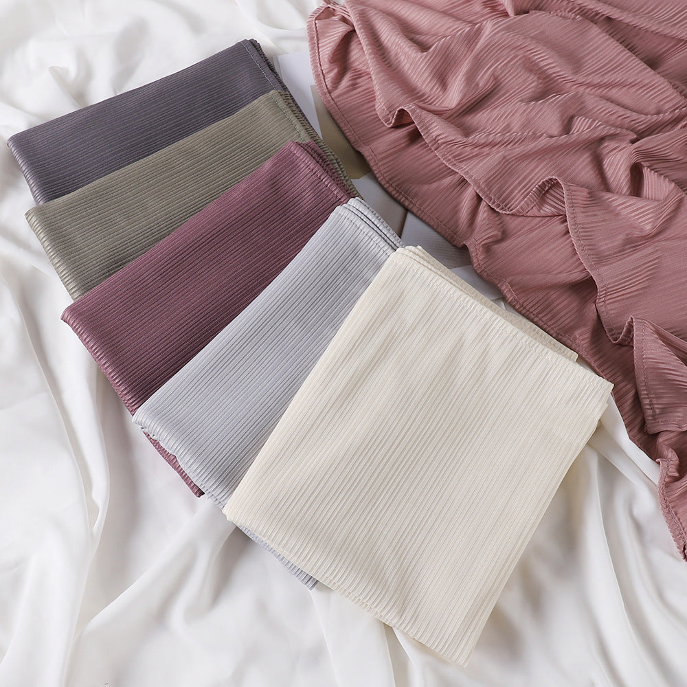 Pila de pañuelos de jersey de algodón de hilo de varios colores en tonos malva, gris y beige.