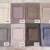 A set of nine folded soft modal rayon hijab fabric swatches in various neutral tones and shades.