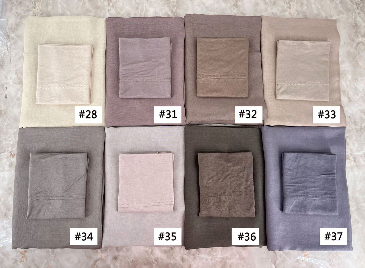 A set of nine folded soft modal rayon hijab fabric swatches in various neutral tones and shades.