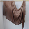 Pañuelo de hijab de algodón rayón en degradado ombré colgado en una varilla de madera.