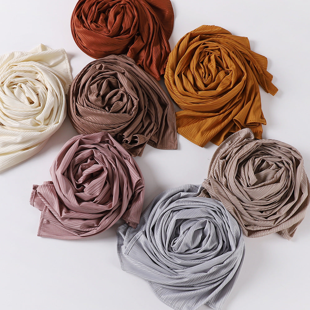 Colección de nueve pañuelos de jersey de algodón enrollados en tonos tierra como óxido, beige y verde oliva