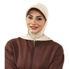 Une femme portant un bonnet hijab beige couvrant et un haut à fermeture éclair marron.