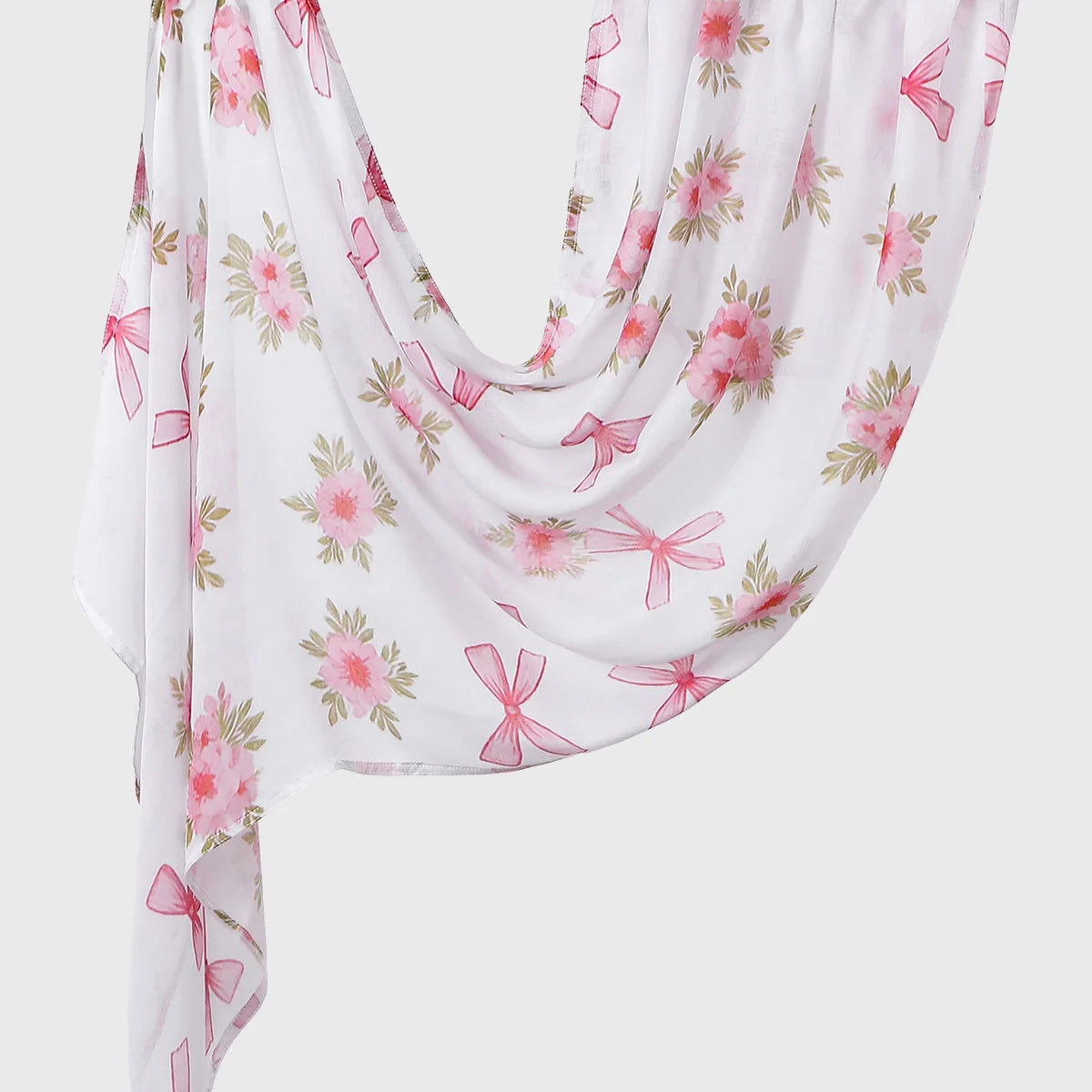 A flowing white linen hijab scarf with a pink floral print and pink bows