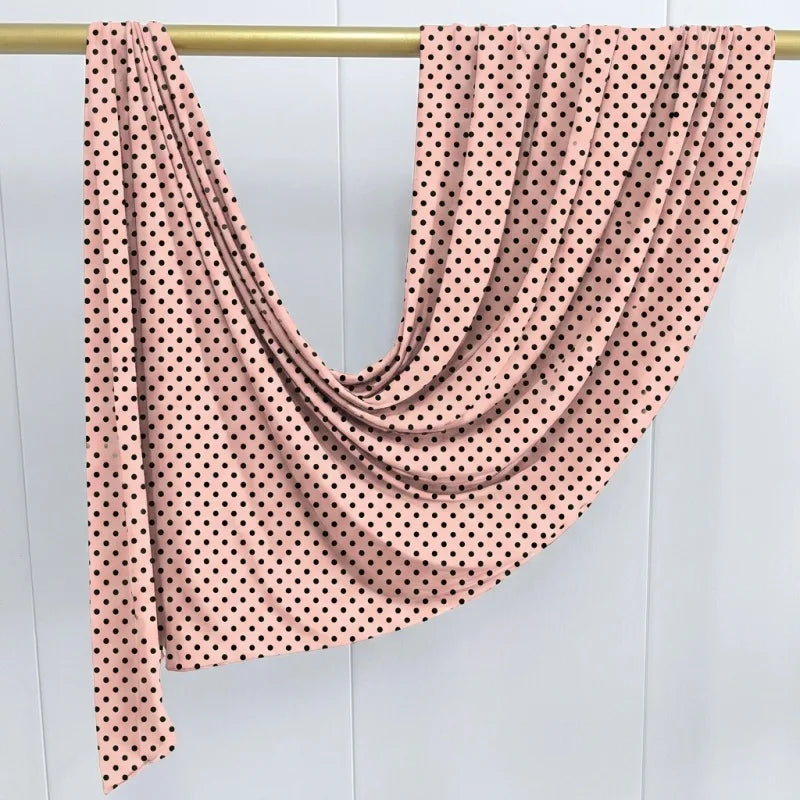 Rosa Turban-Schal mit schwarzen Polkadottern über einem goldenen Haken.