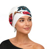 Eine Frau modelliert einen weißen Turban mit Blumenmuster in Rot- und Grüntönen.