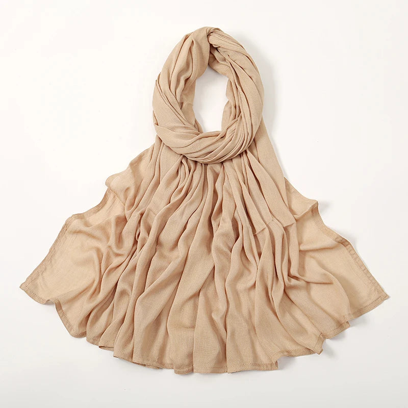 Pañuelo de algodón rayón beige drapeado alrededor del cuello y cayendo sobre los hombros.