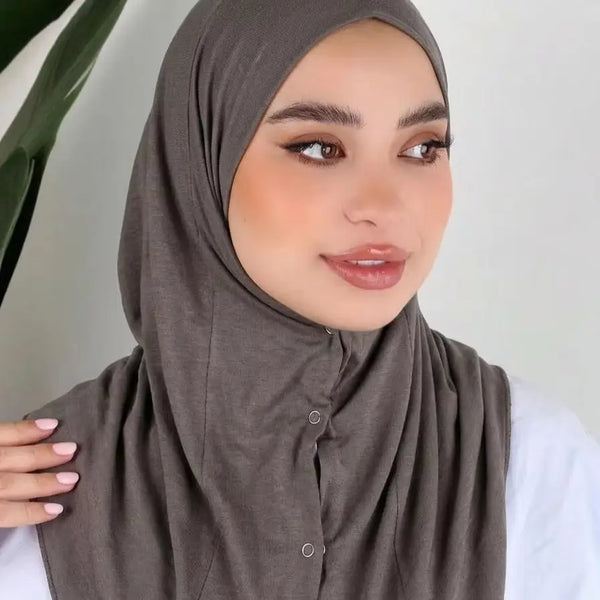 A woman wearing a solid brown instant cotton jersey hijab, looking to the side.