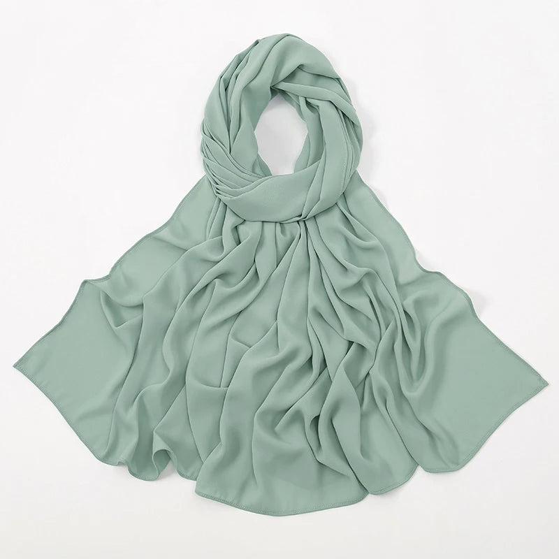 Weiches salbeigrünes Chiffon-Tuch, gebunden in einem fließenden Schleier für einen muslimischen Hijab.