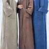 Three women wearing elegant trench coats in shades of beige, brown, and blue.