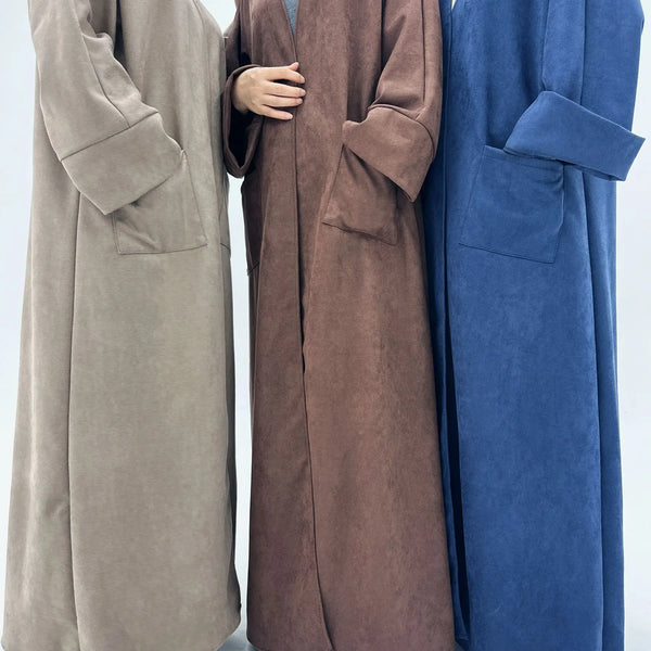 Three women wearing elegant trench coats in shades of beige, brown, and blue.