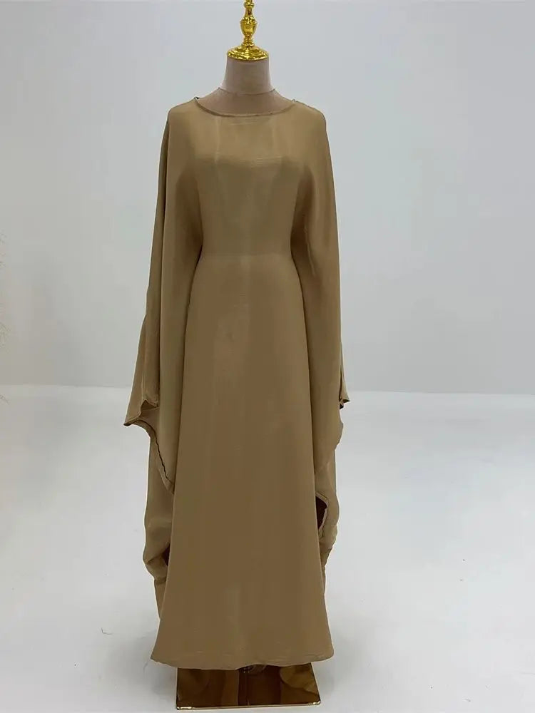 Abaya de satén beige con corte batwing exhibida en maniquí.