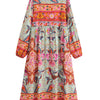 Vestido maxi de manga larga floral con patrones rosa, naranja y verde y flecos decorativos.