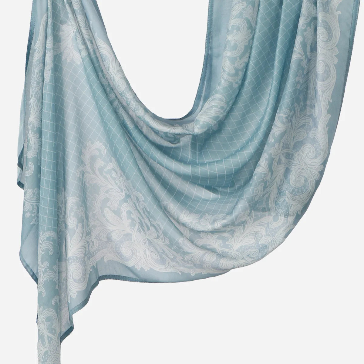 A light blue printed linen hijab scarf draped elegantly.