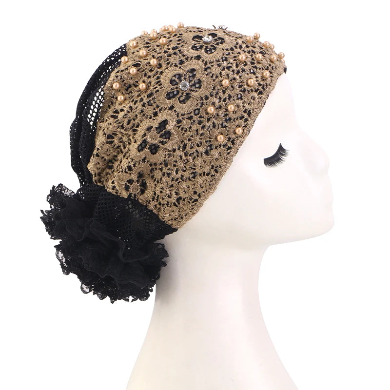Turban elegante de flores de cuentas con encaje negro y detalles dorados, exhibido en maniquí.