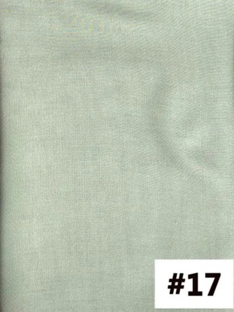 Gros plan sur le tissu d'un foulard modal vert sauge clair.