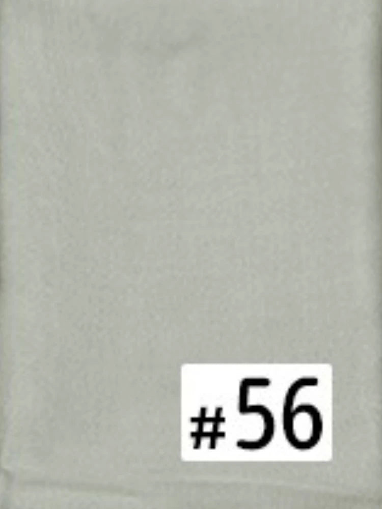 Une étiquette blanche avec le numéro 56 est placée sur un fond de tissu gris clair.